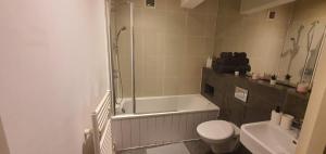 a bathroom with a tub and a toilet and a shower at 2 modern double rooms in the heart of Brick lane in London