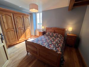 1 dormitorio con 1 cama, suelo de madera y armarios en Le Mont de Piegut en Piégut-Pluviers