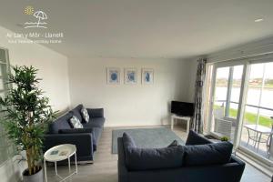 un soggiorno con 2 divani e una TV di Ar Lan Y Mor - Stunning 2 bed coastal apartment a Llanelli