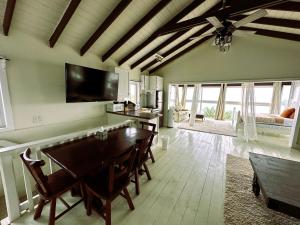 a dining room with a table and a tv at MIRAMAR SUITES in West End