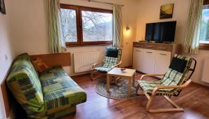 ein Wohnzimmer mit 2 Stühlen und einem TV in der Unterkunft Apartments Oman in Kranjska Gora