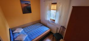 um pequeno quarto com uma cama e uma janela em Apartments Oman em Kranjska Gora