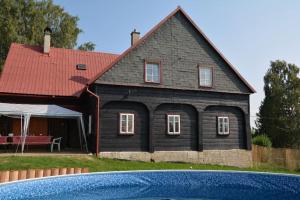 una casa con piscina frente a ella en Chalupa U tří soviček., en Jetřichovice
