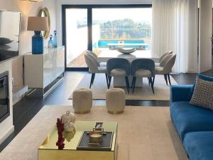Una sala de estar con un sofá azul y una mesa. en Moradia - Vila Golfe Amarante, en Amarante