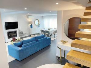 sala de estar con sofá azul y comedor en Moradia - Vila Golfe Amarante en Amarante