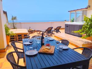 uma mesa azul com copos de vinho no pátio em Penthouse with Jacuzzi and spectacular Sea Views em Nerja
