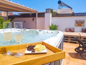 uma banheira de hidromassagem com 2 copos de vinho e queijo em Penthouse with Jacuzzi and spectacular Sea Views em Nerja