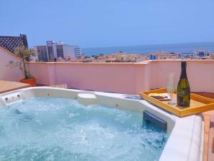 wanna z hydromasażem na balkonie z butelką wina w obiekcie Penthouse with Jacuzzi and spectacular Sea Views w mieście Nerja