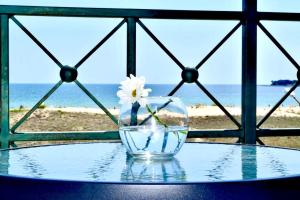 un jarrón de cristal con una flor sentado en una mesa cerca de la playa en Liberty Residence, en Primorsko