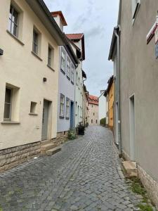 a cobblestone street in an alley between buildings at Erfurt City -Schildchensmühle in Erfurt