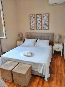 a bedroom with a large white bed with two tables at Theater Penthouse in Corfu Town