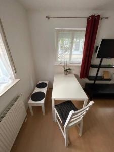 a small room with a white table and a bench at Erfurt City -Schildchensmühle in Erfurt
