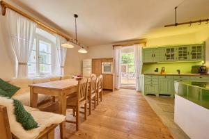 a kitchen and dining room with green cabinets and a table at Chalupa Fara in Dolní Malá Úpa