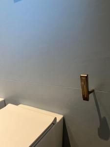 einen Lichtschalter an einer Wand neben einem weißen Kühlschrank in der Unterkunft Casetta Fausta immersa nel Golf Margara. in Fubine