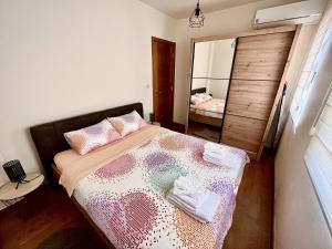 a bedroom with a bed and a large mirror at Fides Stylish Apartments Tivat with Pool in Tivat +13 photos