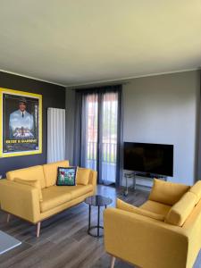 ein Wohnzimmer mit 2 Sofas und einem Flachbild-TV in der Unterkunft Casetta Fausta immersa nel Golf Margara. in Fubine