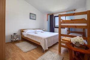 a bedroom with a bed and a bunk bed at Apartments Anica - Vlašići Island Pag in Vlašići