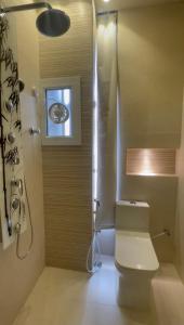 a bathroom with a toilet and a shower with a window at Rateel Apartments in Salalah +13 photos