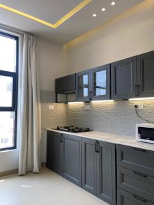 a kitchen with gray cabinets and a counter top at Rateel Apartments in Salalah