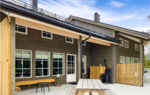 Cette maison en bois dispose d'une terrasse et d'une table. dans l'établissement Cozy Home In Nordfjordeid With Wifi, à Nordfjordeid