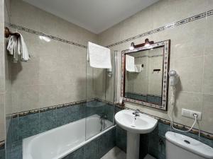 a bathroom with a sink and a tub and a toilet at Hostel Conil in Conil de la Frontera