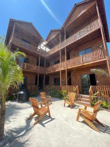 a wooden house with benches in front of it at Krak-Inn Holbox - Pet Friendly in Holbox Island +71 photos
