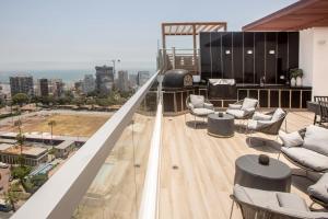 - un balcon avec des chaises et des tables dans un bâtiment dans l'établissement Grau by Wynwood House, à Lima
