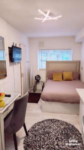 1 dormitorio con cama, escritorio y silla en Studio Flat, close to o2 Arena and City Airport en Woolwich