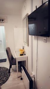 a living room with a chair and a table with a television at Studio Flat, close to o2 Arena and City Airport in Woolwich