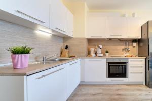 una cocina con armarios blancos y fregadero en Summertime in Varna South Bay Beach Residence en Varna