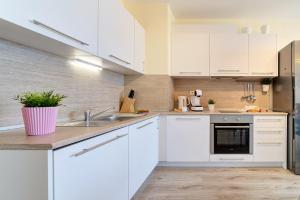 a kitchen with white cabinets and a sink at Summertime in Varna South Bay Beach Residence in Varna City