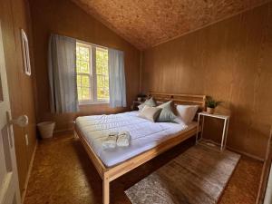Un dormitorio con una cama con dos zapatos. en Archie's Lakeside Cabin en Wolfville