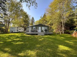a large yard with a house and a trailer at Archie's Lakeside Cabin in Wolfville