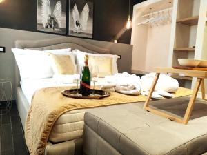 a bedroom with a bed with a bottle of champagne at Ti Scialíi Suites Rooms and Relax in Pachino