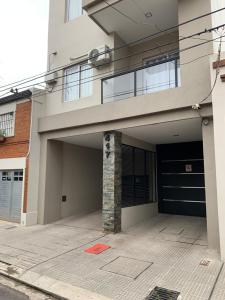 a building with a garage with a driveway at Amaru - Departamento céntrico con cochera in Corrientes