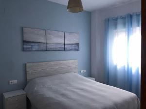 1 dormitorio con cama blanca y ventana en Apartamento Conil, en Conil de la Frontera