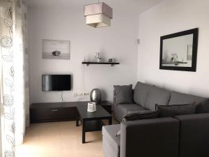 sala de estar con sofá y TV en Apartamento Conil, en Conil de la Frontera