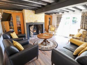 a living room with leather furniture and a fireplace at Holly Cottage in Lincoln