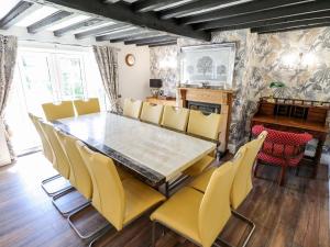 a dining room with a table and yellow chairs at Holly Cottage in Lincoln