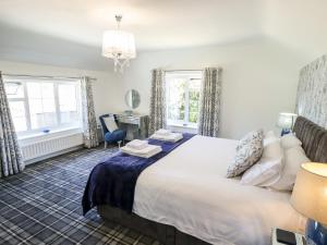 um quarto com uma cama grande e 2 janelas em Holly Cottage em Lincoln