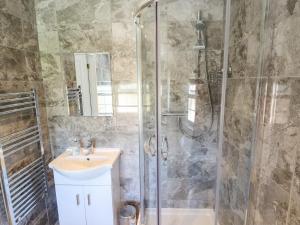 uma casa de banho com um lavatório e um chuveiro em Holly Cottage em Lincoln