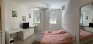 1 dormitorio con cama, escritorio y espejo en City Apartments en Mostar