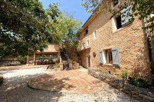 a stone building with a patio in front of it at Campagne du XVII au luxe simple in Lorgues