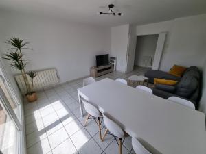 a living room with a white table and a couch at Immense RoofTop Lyon 3 chambres, 4 places de parking in Lyon