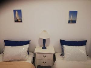 a room with two beds and a lamp on a side table at Apartamento Saint Martin in Armação de Pêra