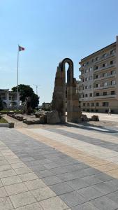 un bâtiment avec un monument au milieu d'une rue dans l'établissement Central Apartment, à Mangalia