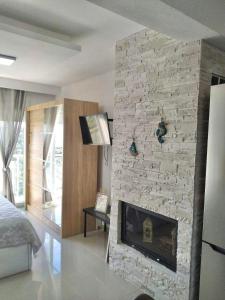 a living room with a stone wall with a fireplace at Chrystal Boutique Suite in Skala Marion