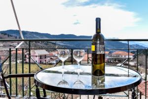 a bottle of wine and two wine glasses on a table at ΑΘΑΜΑΣ in Athamanio