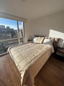 een slaapkamer met een groot bed en een groot raam bij Amazing 2bed Penthouse BalconyView La Carolina 8FL in Quito