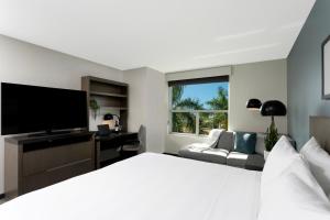 Dormitorio con cama, escritorio y TV en Hyatt House San Juan, en San Juan